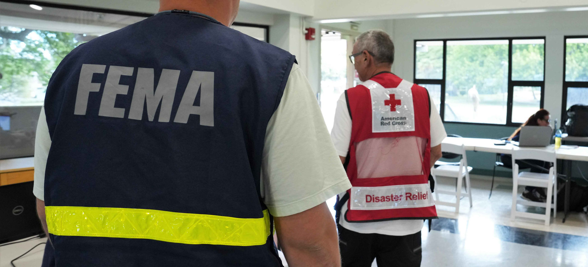 FEMA employee and American Red Cross volunteer stand next to each other. 