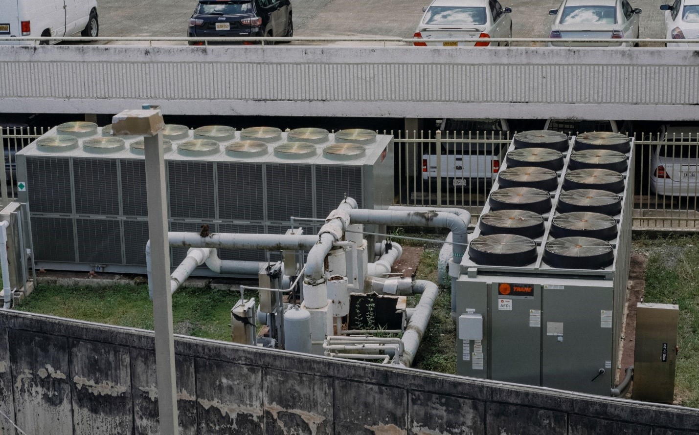 A parking lot with a big fans in front of them 