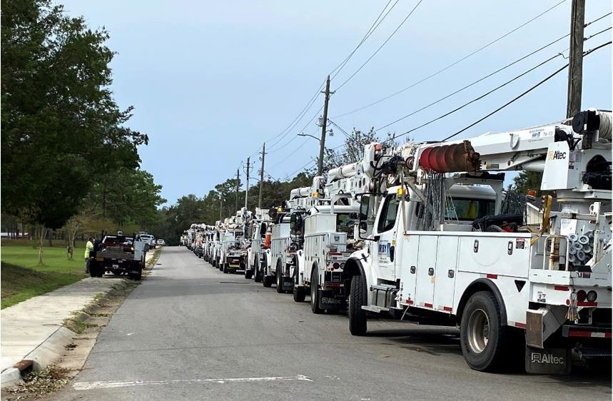 Power crews stage equipment as they work to repair damaged power lines and restore electricity to the area.