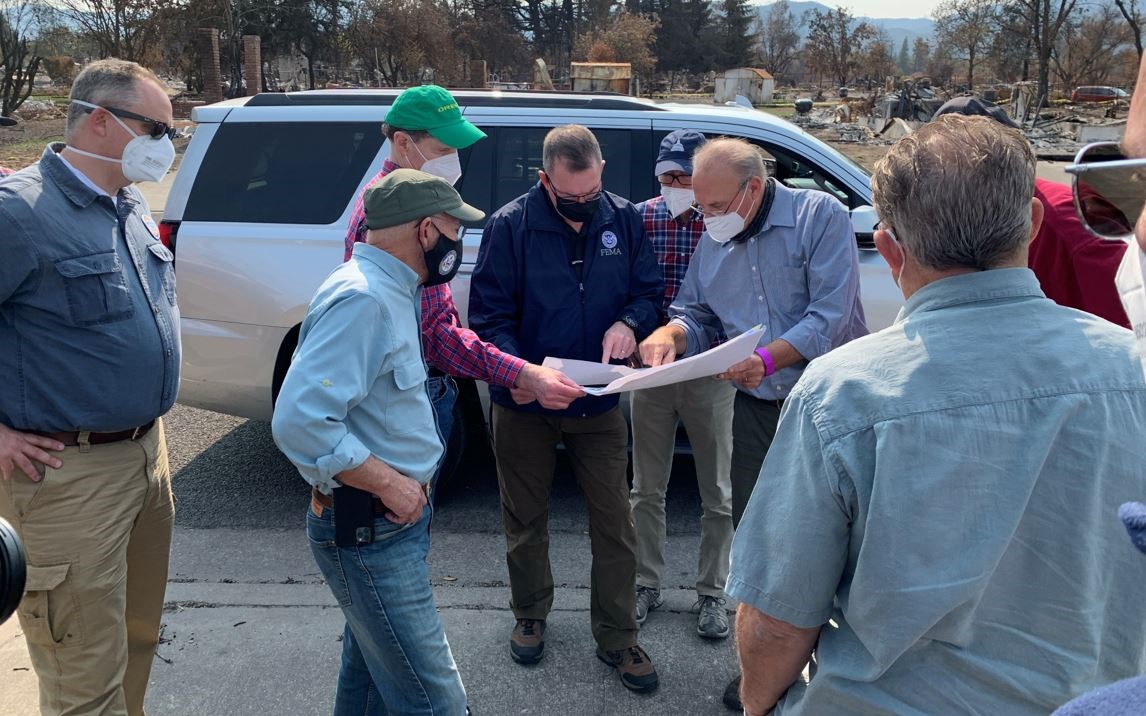 FEMA Administrator Pete Gaynor (center) and Jackson County Emergency Operations Director John Vial study fire-damaged areas in the Jackson County area during the administrator's visit to Oregon. U.S. Rep. Peter DeFazio, U.S. Sen. Ron Wyden and U.S. Rep. Greg Walden also look on. 