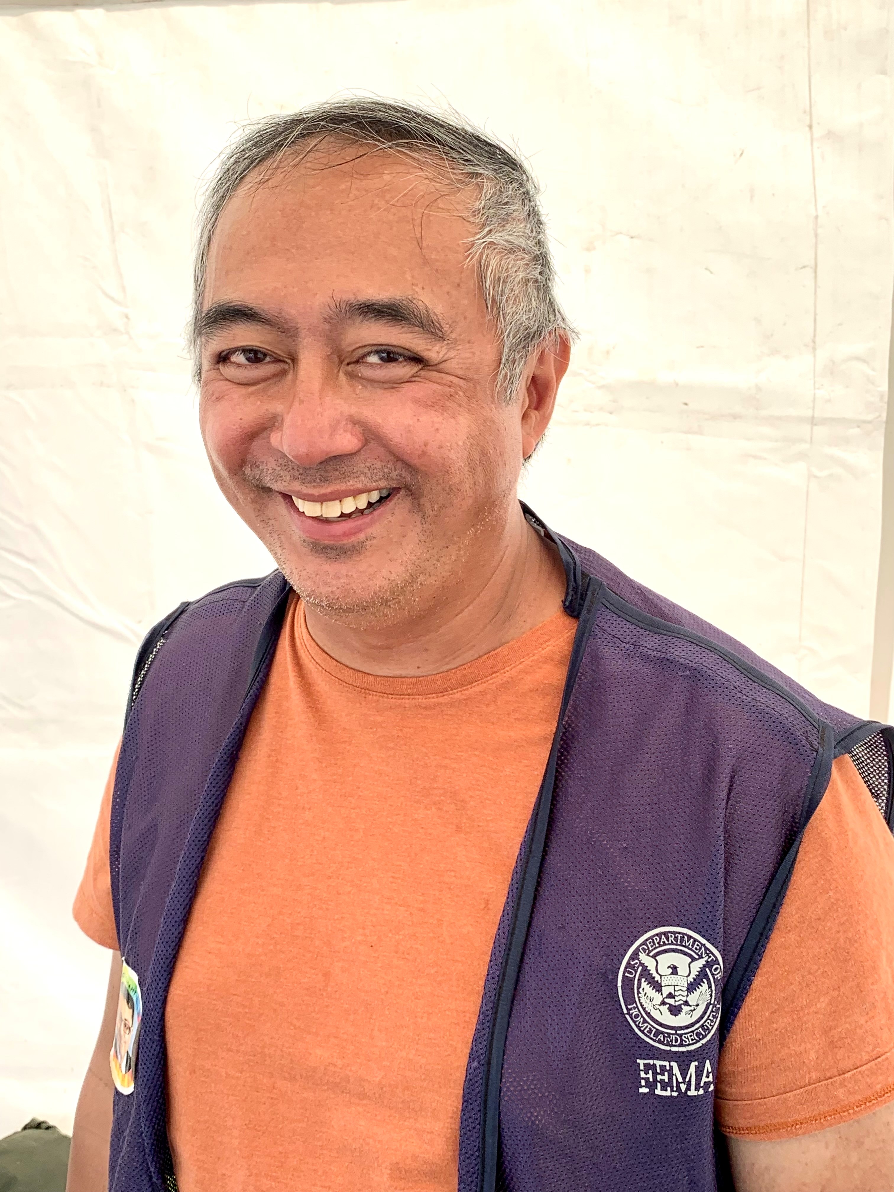 image of man wearing a fema vest, smilling