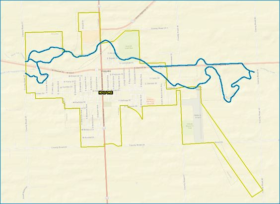 A photo of a map of a geographic area. The map includes streets and street names. A blue winding line cuts through the upper portion of the graphic.