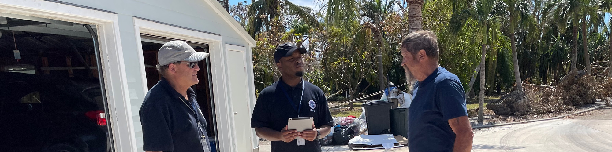 FEMA personnel talk to a disaster survivor