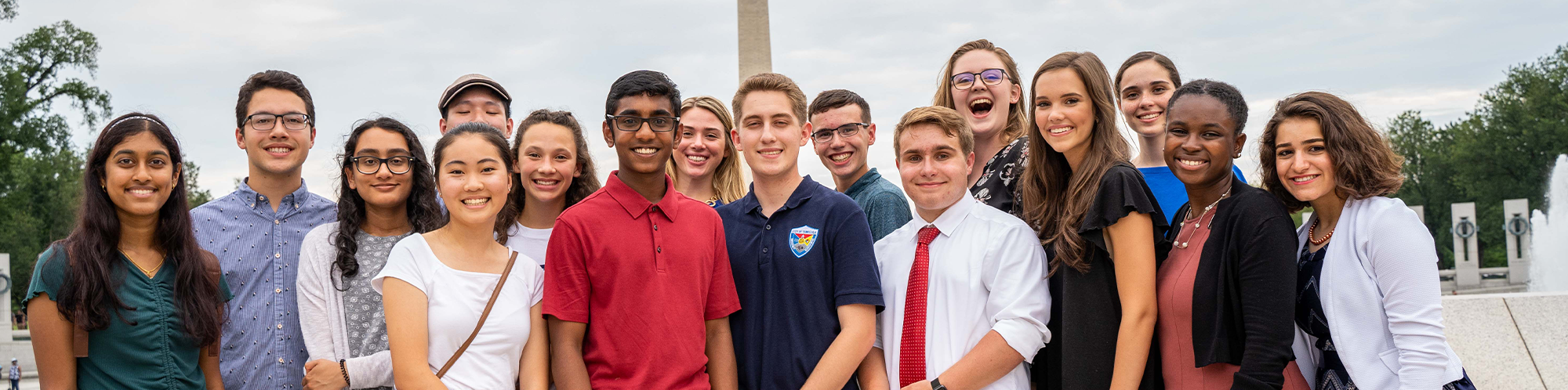 Un grupo de jóvenes frente al monumento conmemorativo de la Segunda Guerra Mundial y el Monumento a Washington.