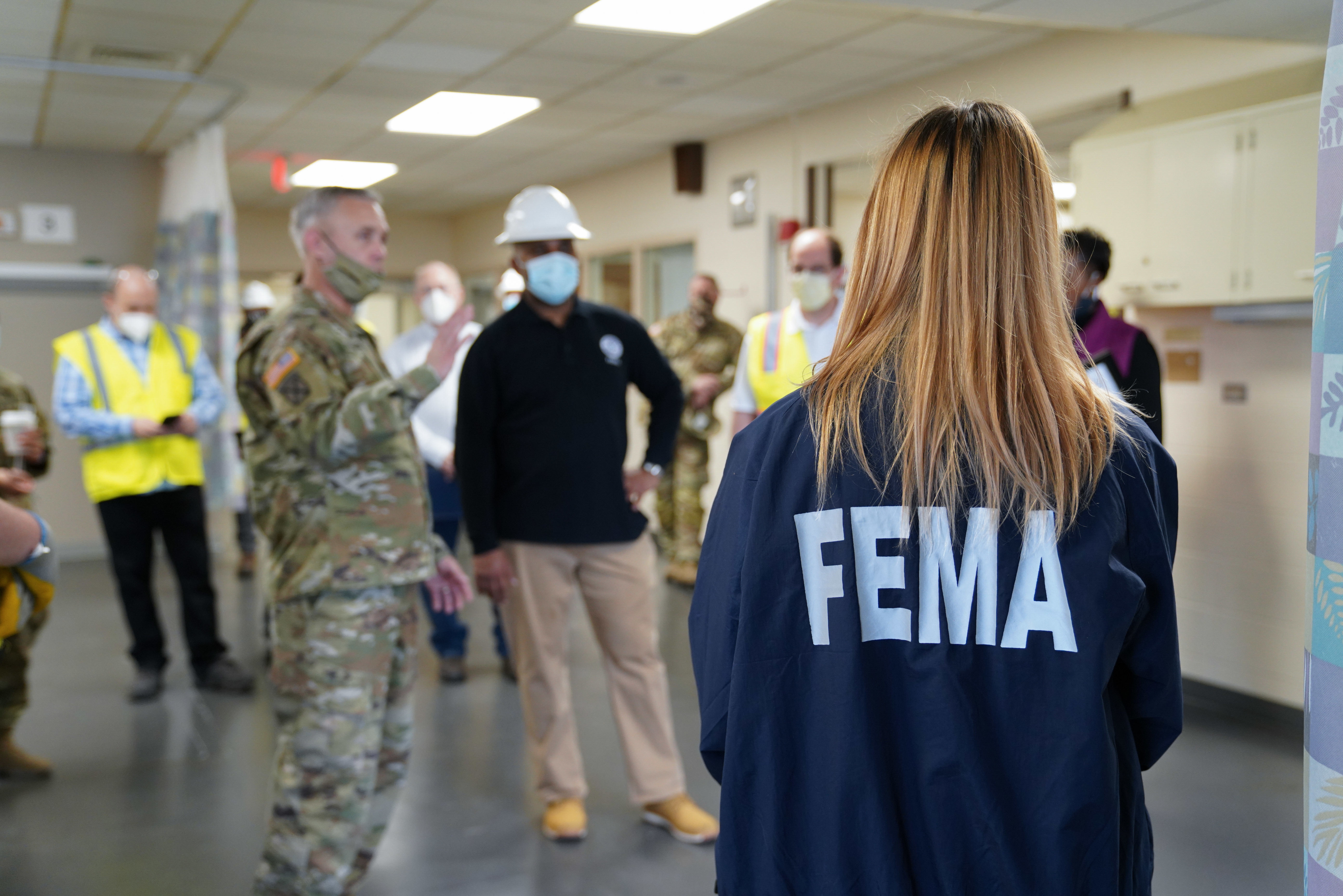 Women standing with FEMA on the back of her jacket 