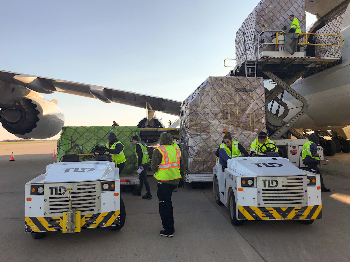 Airport staff load vehicles with cargo.