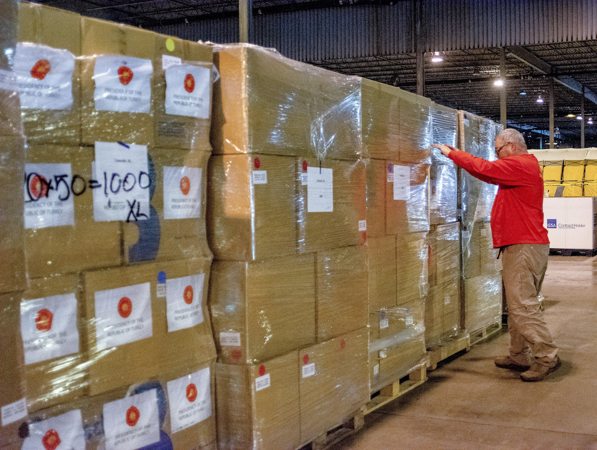 A man inspects boxes of supplies.