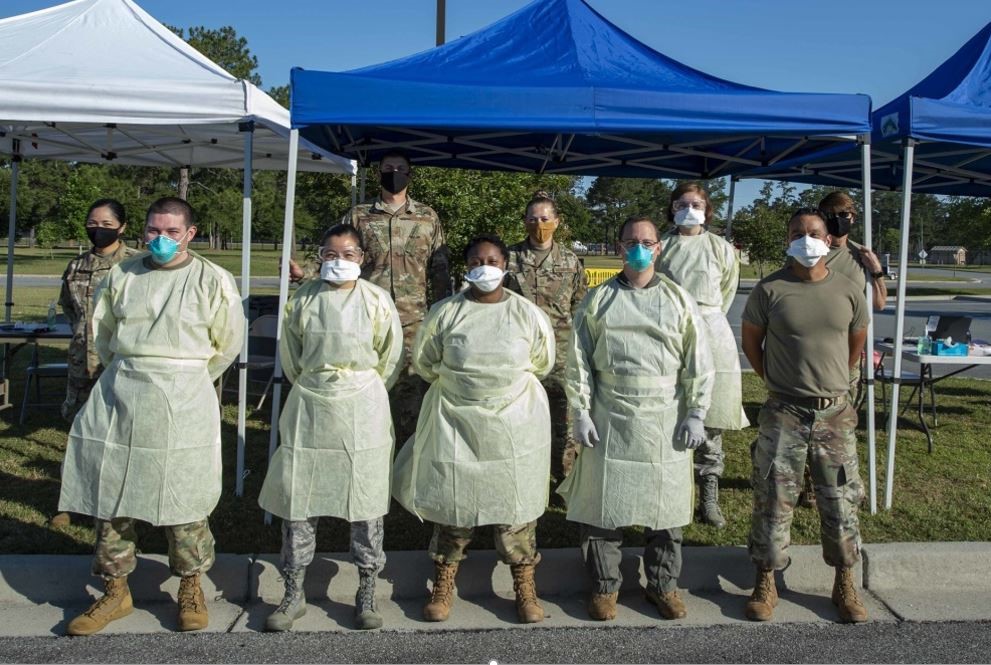 9 soldiers standing in front of a tent