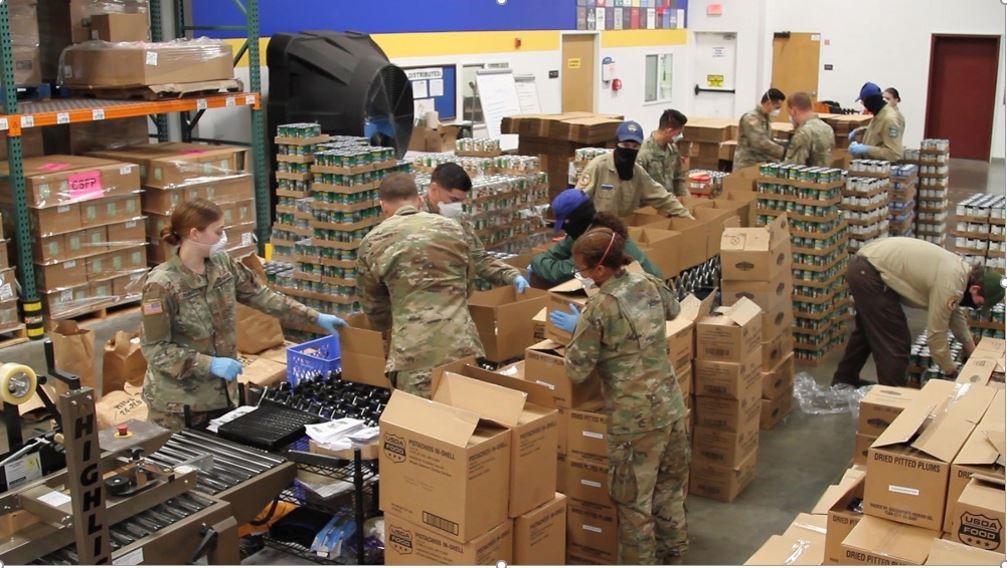 9 soldiers putting can goods in boxes