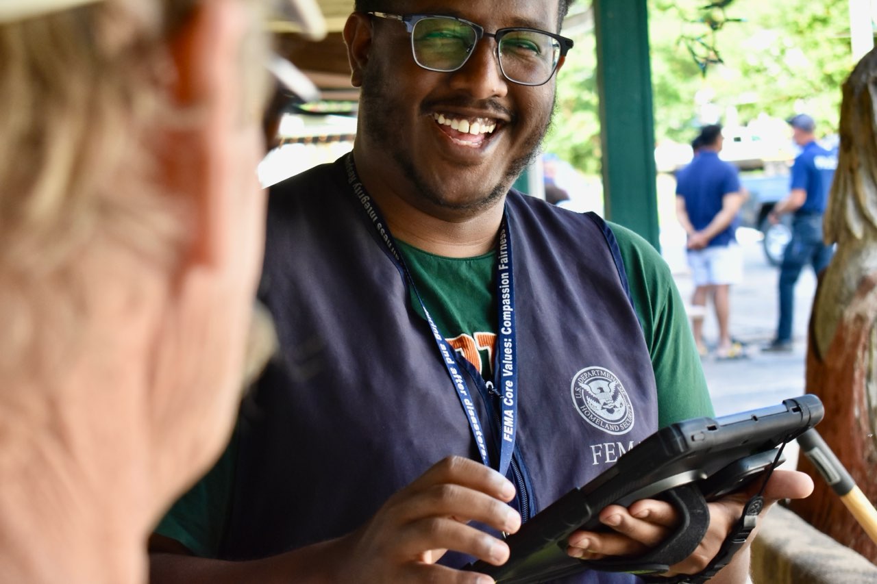 Photo shows Disaster Survivor Assistance Team Specialist Mo helping a Damascus, Va. resident fill out an application for federal assistance on Oct. 3, 2024. 