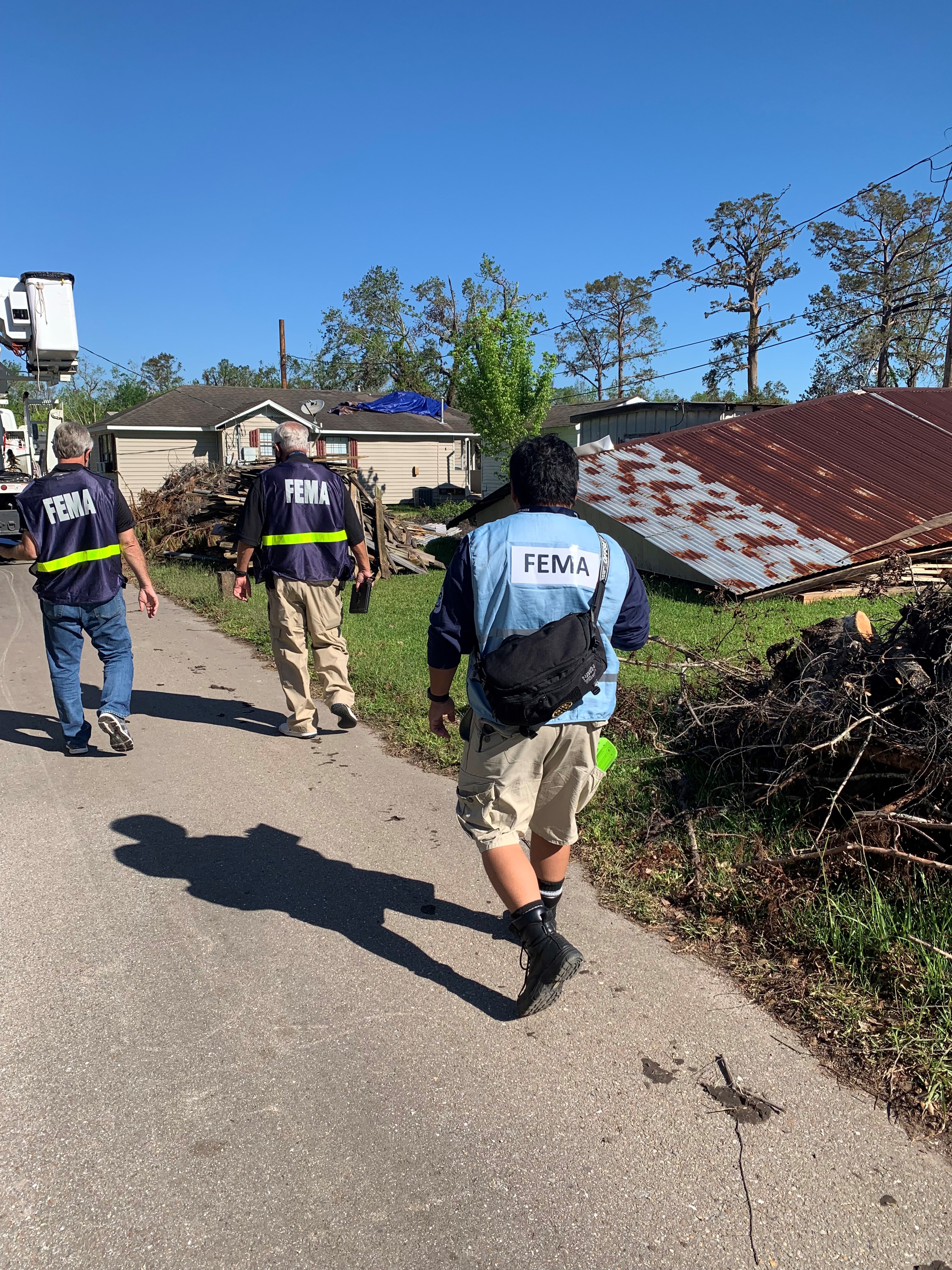 Three FEMA Corps members go door-to-door to help with registration.