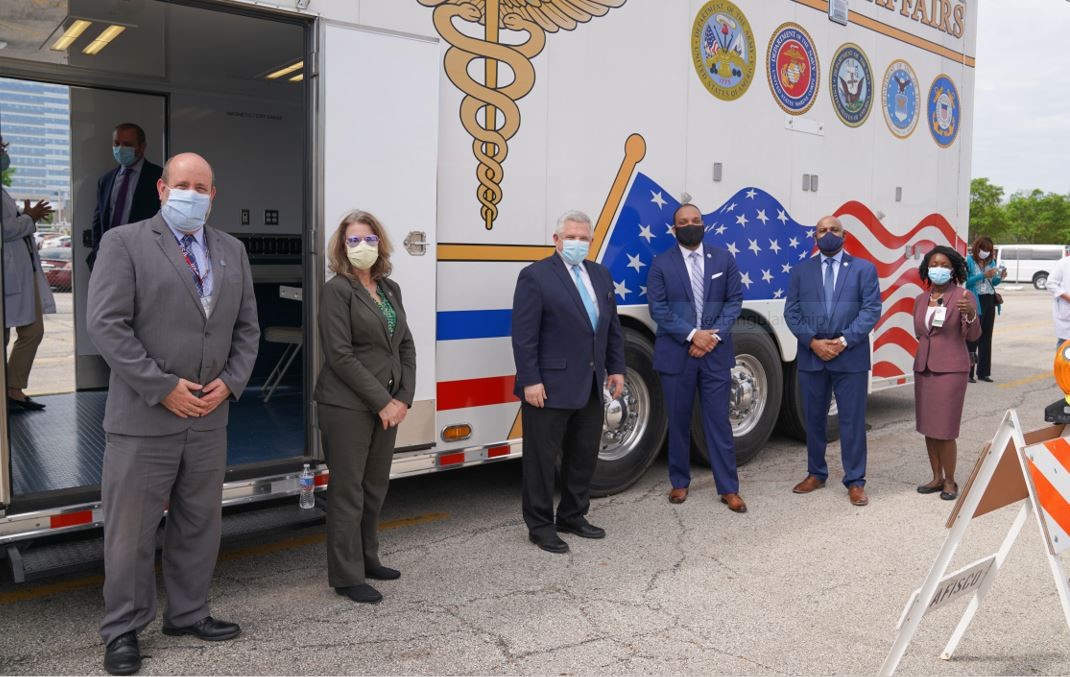 4 males and 2 women standing in front of a mobile unit.