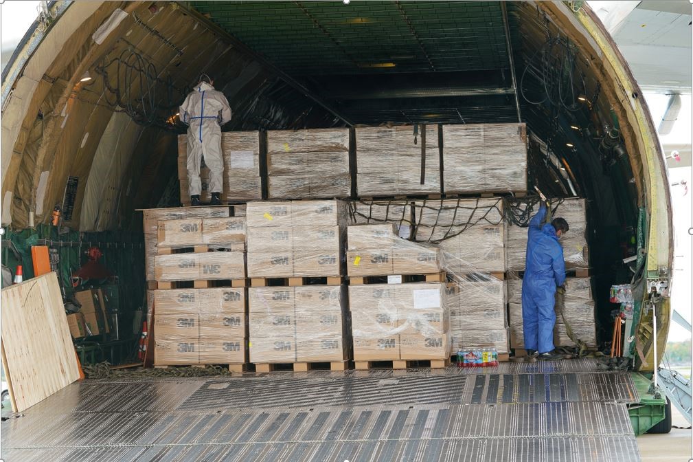 Two mean securing big boxes of mask on airplane