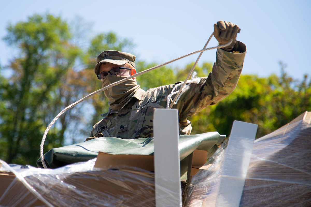 Military man ties up supplies.