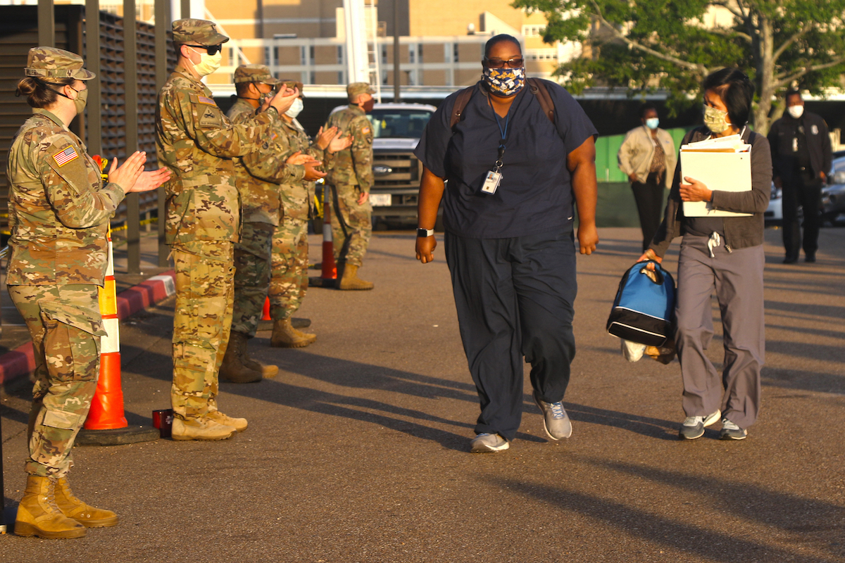 Soldiers applaud as doctors, nurses and hospital staff enter.