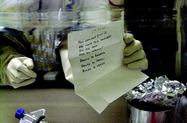 Figure 2: Laboratory technician holding the anthrax-laced letter addressed to Senator Leahy after safely opening it at the U.S. Army's Fort Detrick biomedical research laboratory in November 2001