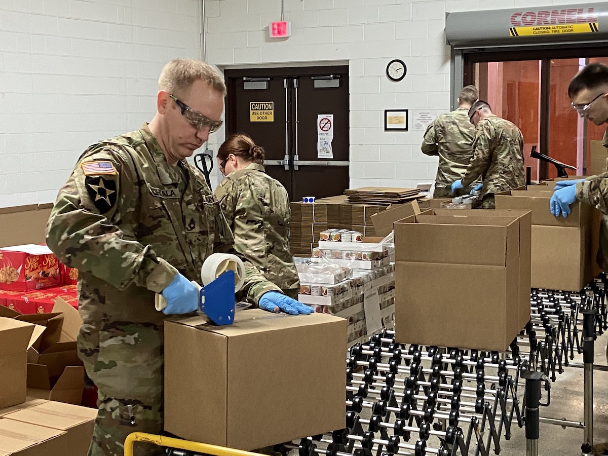 A National Guard Soldier tapes a box of medical supplies for shipment.
