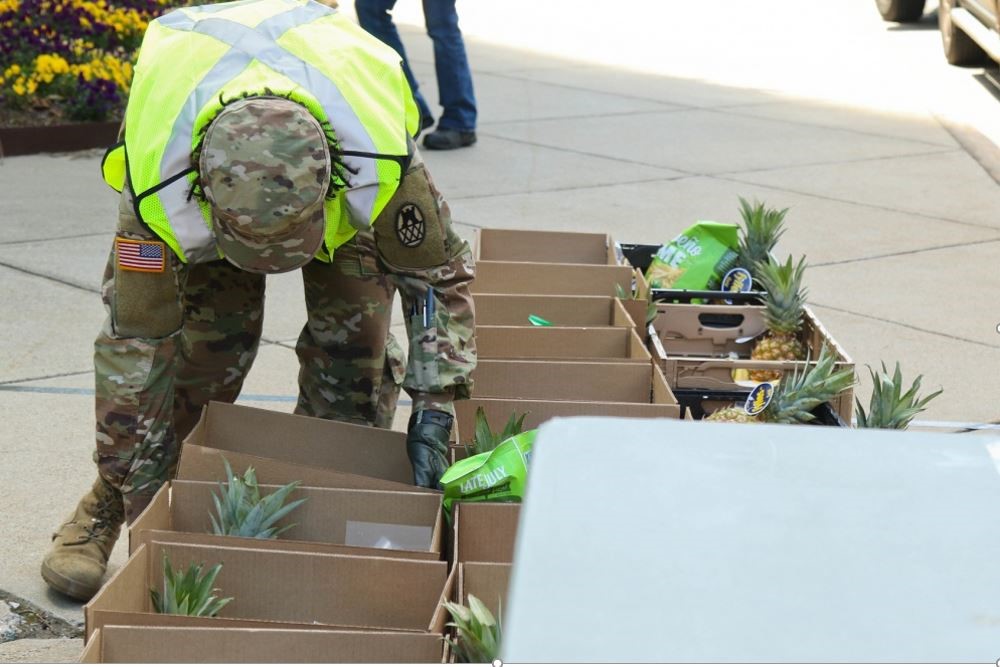 A soldier picking up a box of food