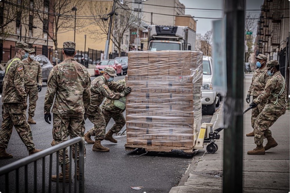 6 male solider pulling a big cart of huge boxes