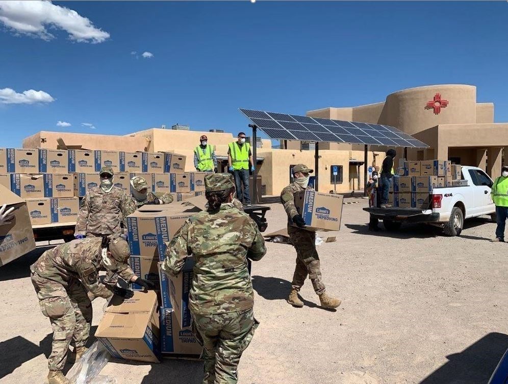 10 soldiers unloading Lowes boxes from the back of a big truck
