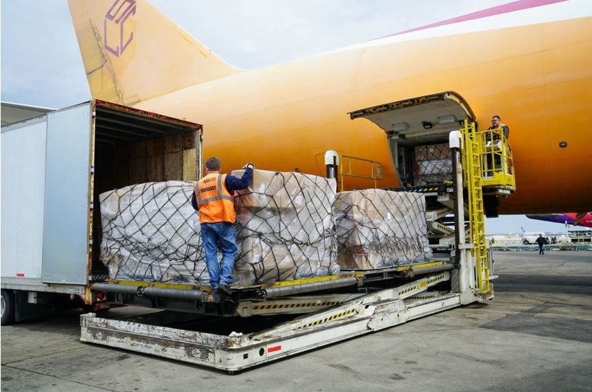 A man unloading big boxes of an airplane