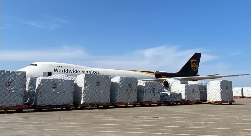8 plus big stacks of boxes in front of an UPS airplane