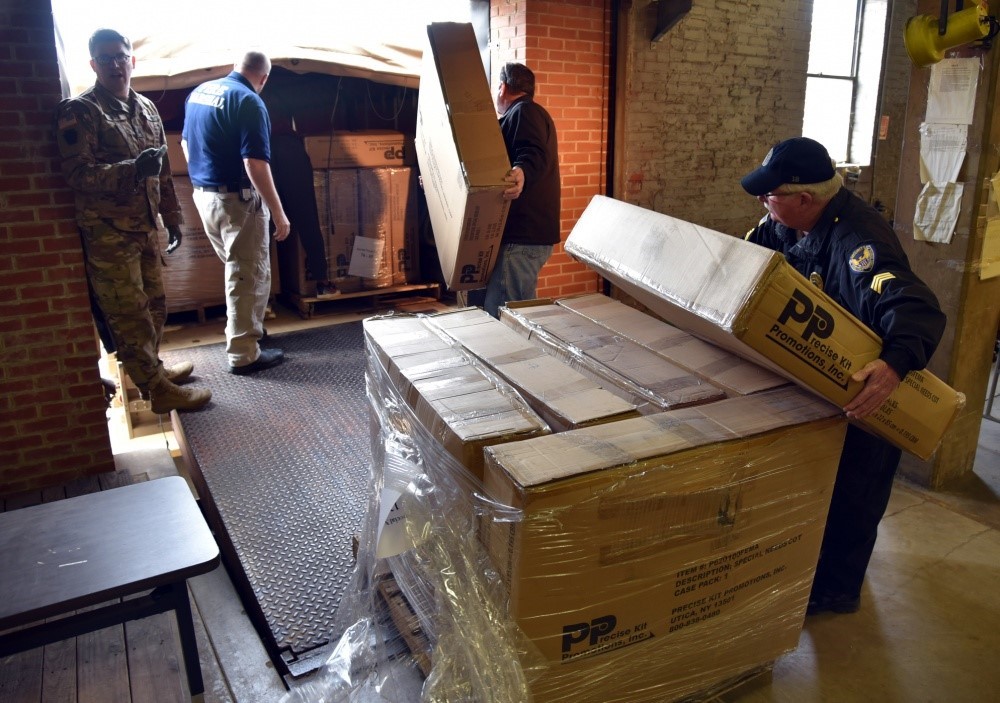 4 men loading boxes into a trailer