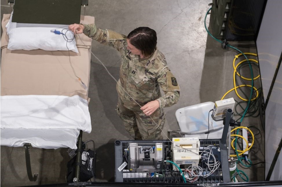 A female soldier setting up medical equipment