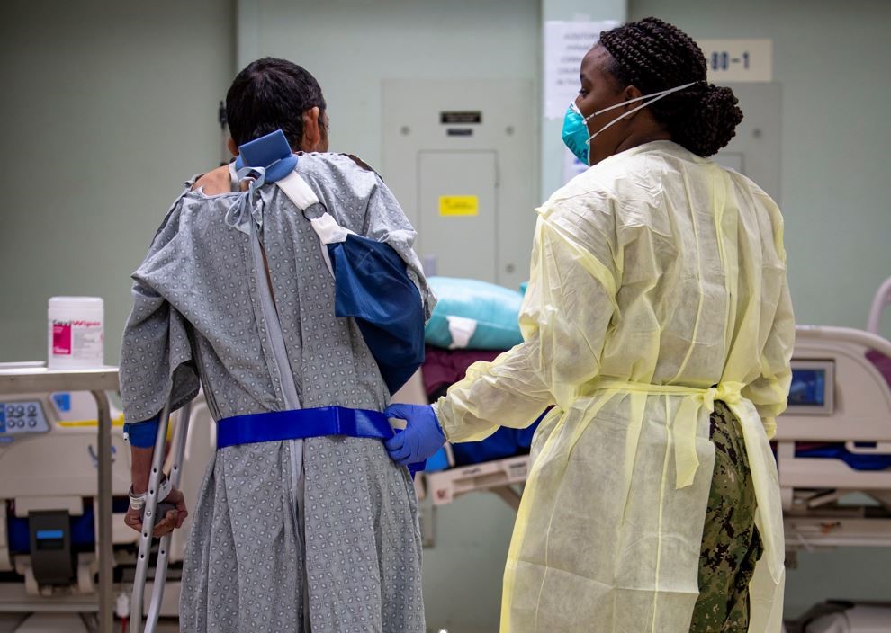 A female doctor helping a patient walk