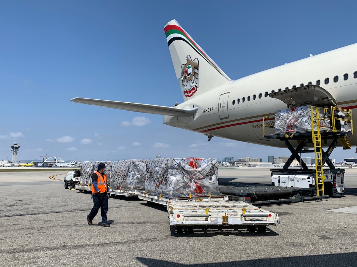 An airplane parked at an airport, as cargo is unloaded.