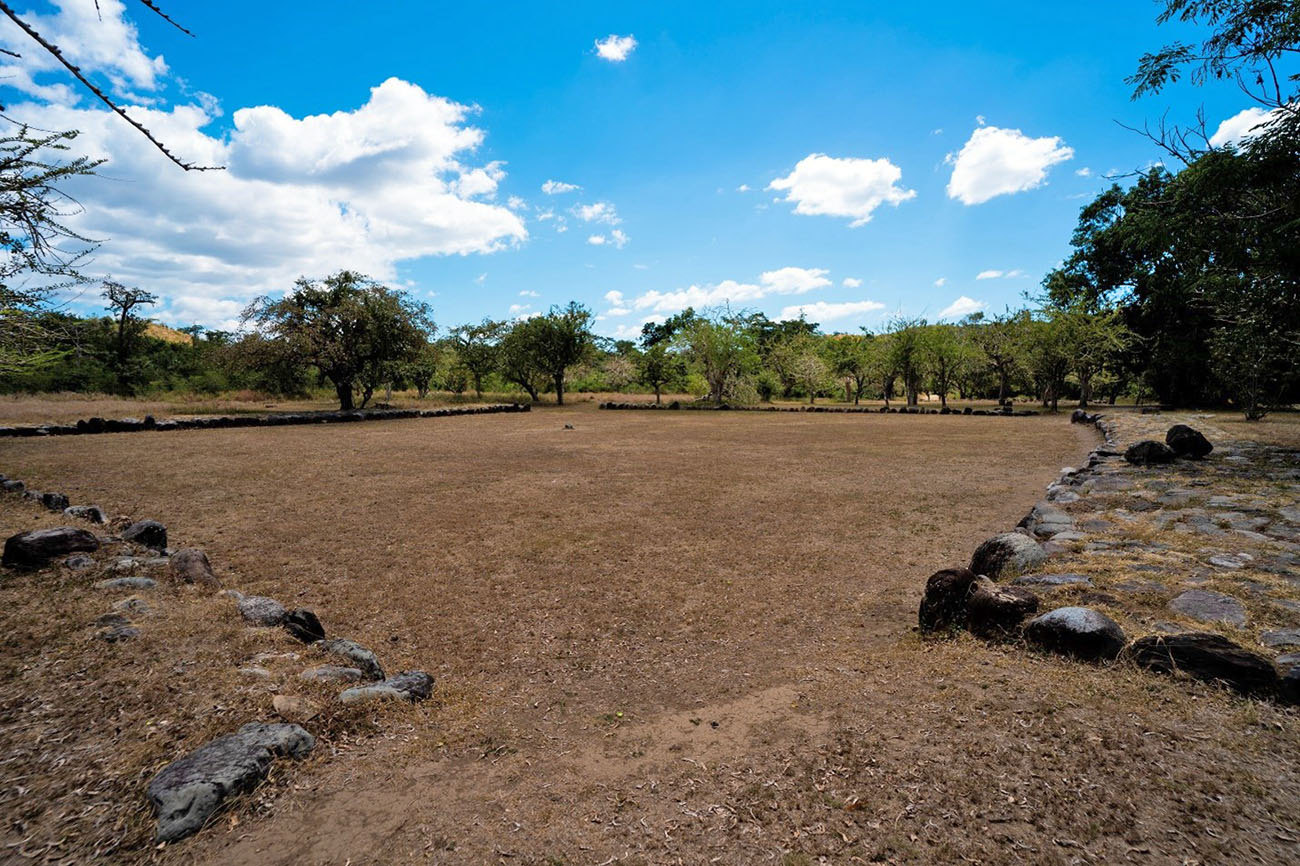 View of a dirt field surrounded by rocks.