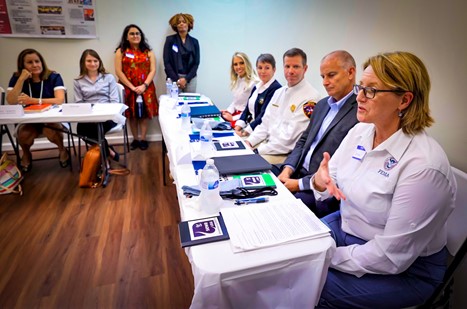 FEMA Administrator Deanne Criswell at a table with a mix of men and women talking