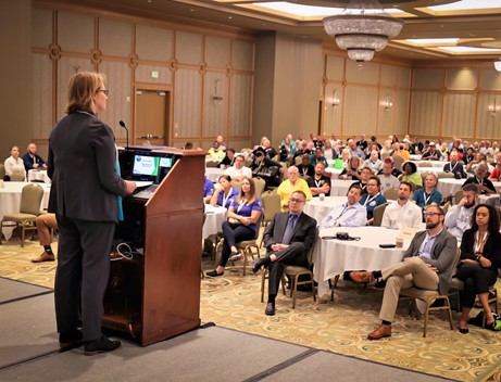 FEMA Administrator Deanne Criswell speaking in front of a crowd of people in a ball room