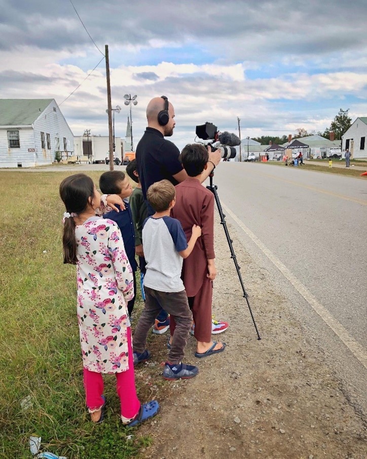 Children watching Ricardo capture photos with his camera.