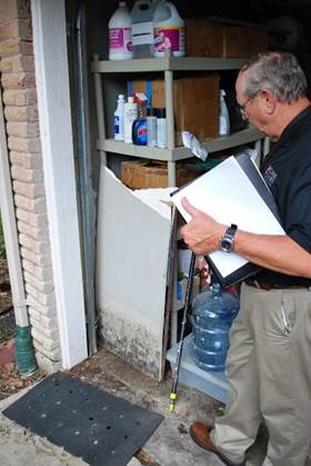 A man with a binder looking inside a garage.