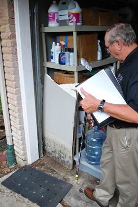 A man with a binder looking inside a garage. 