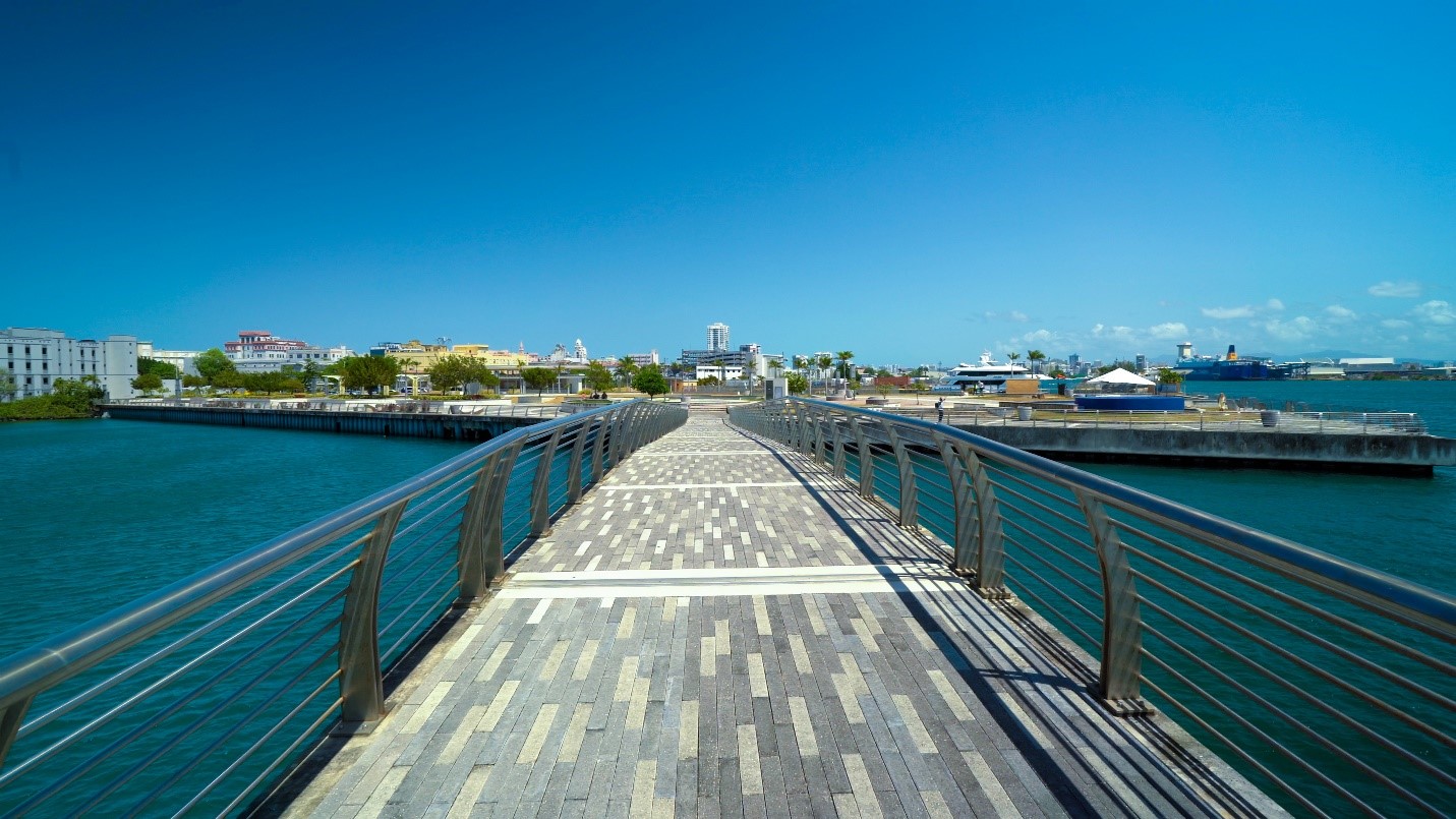 A boardwalk with a view on the ocean on both sides with Bahia Urbana.