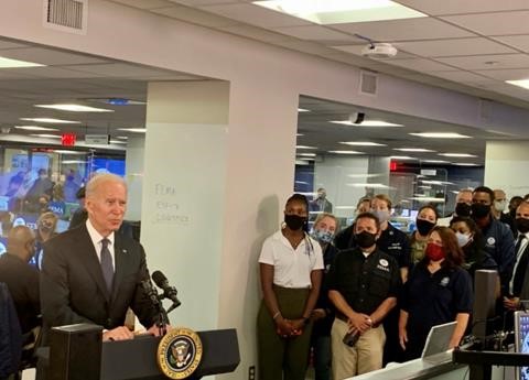 President Joseph R. Biden, Jr. talking in front of a podium with multiple fema staff standing beside and behind him in the nrcc 