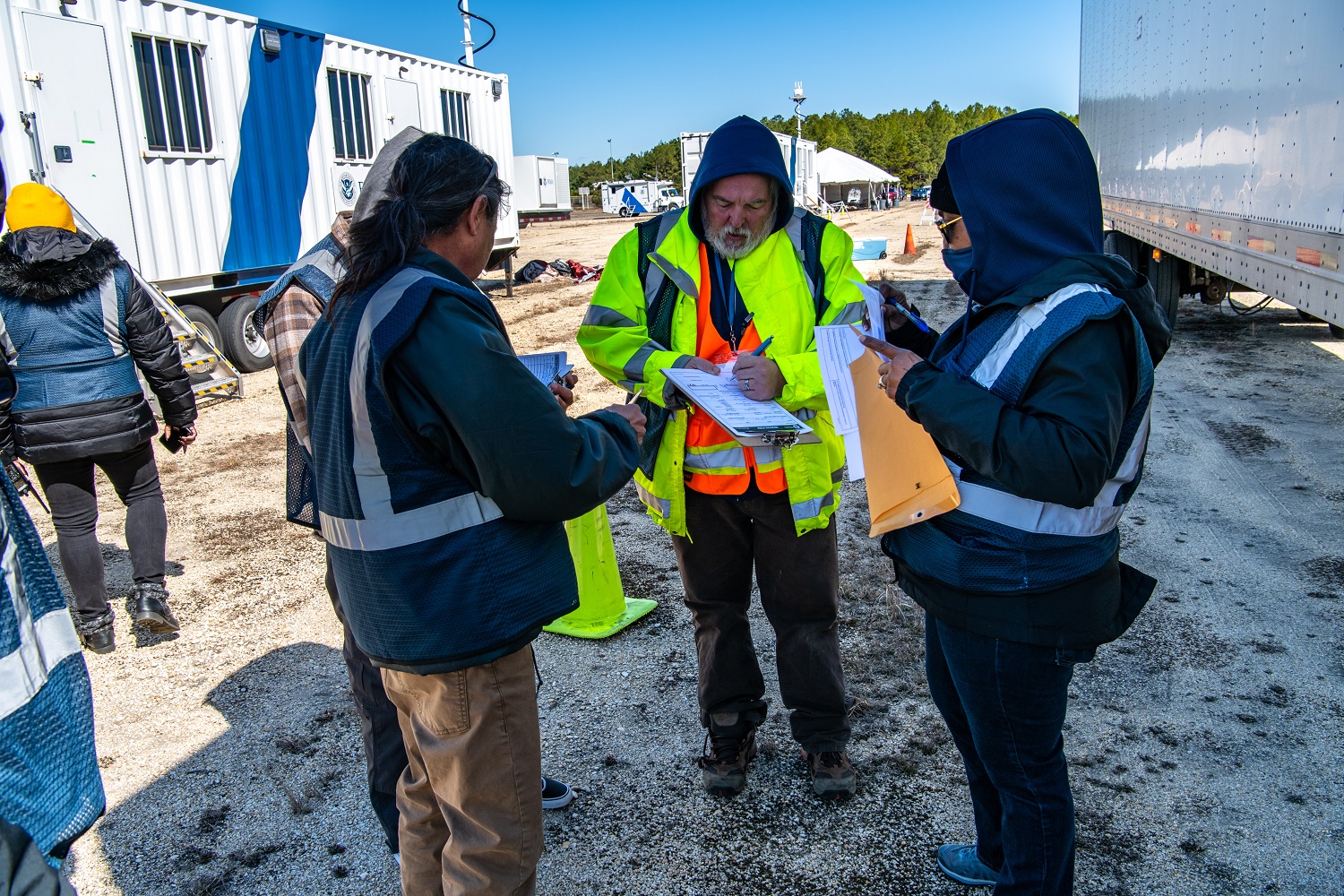 Employees in FEMA safety vests on a cold day.