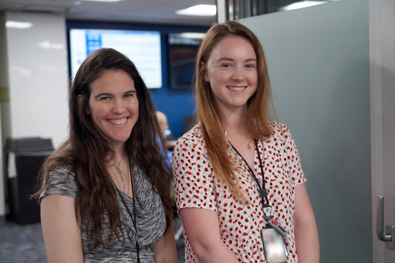 Two smiling young women in the office.