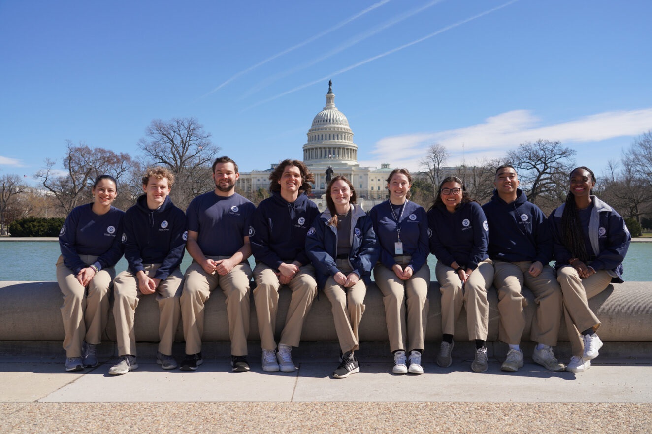 Group of young people wearing FEMA polos with the U.S. Capitol in the background.
