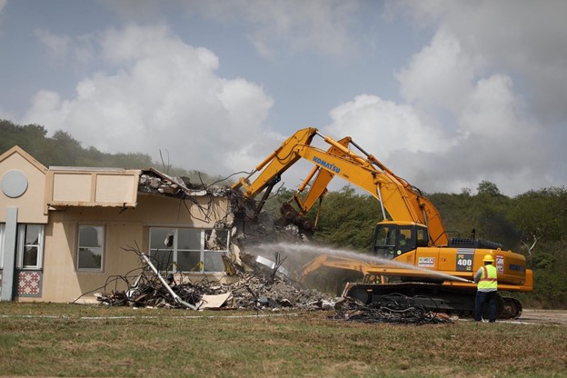 Yellow crane demolishing building.