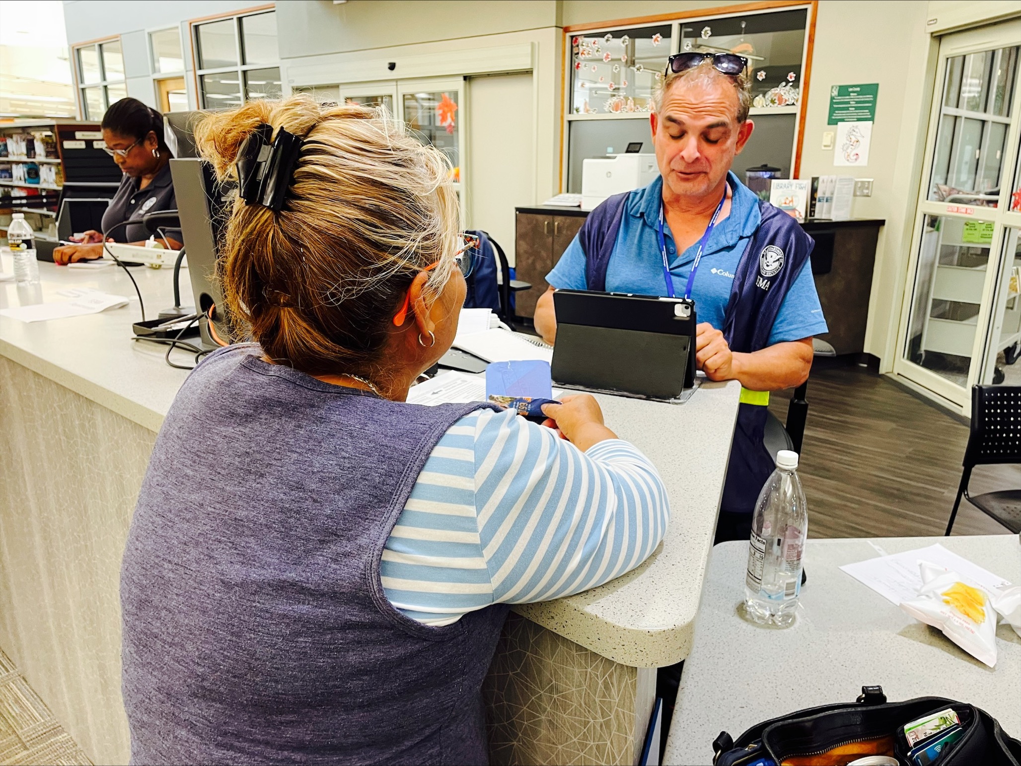 A FEMA Disaster Survivor Assistance team member provides registration services for Hurricane Ian survivors at the Disaster Resource Center located at the Lakes Regional Library. 