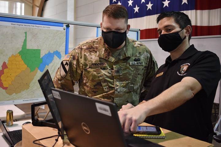 Sgt. Nicholas Rhodes, with the West Virginia Army National Guard, left, and Shawn Nagle, from the National Parks Service Interior Region 2 office in Atlanta, seen on March 23, 2021, helped support the West Virginia Division of Emergency Management at the state Joint Interagency Task Force for vaccinations at the National Guard base in Charleston, W.Va. Nagle was part of the federal response effort assisting with the West Virginia FEMA team’s planning function. 