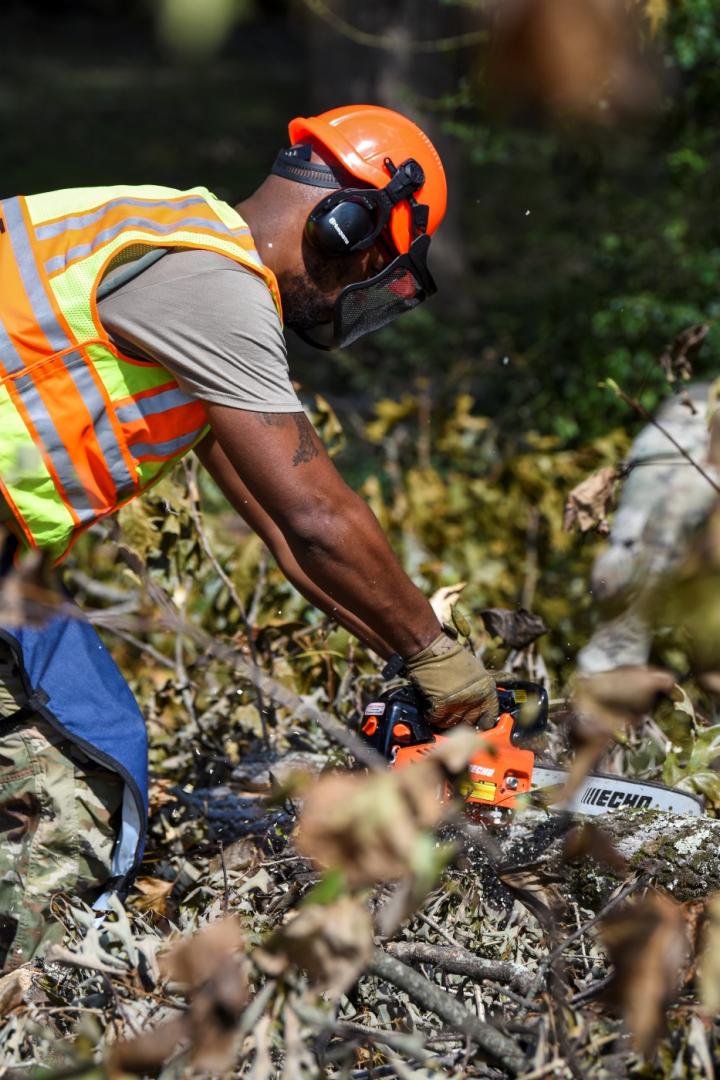 U.S. Air Force Senior Airman Christopher Daniels, a power production technician with the 169th Civil Engineer Squadron, South Carolina Air National Guard, cuts downed trees to assist with debris removal in Gaffney, South Carolina, following Hurricane Helene, Oct. 2, 2024.