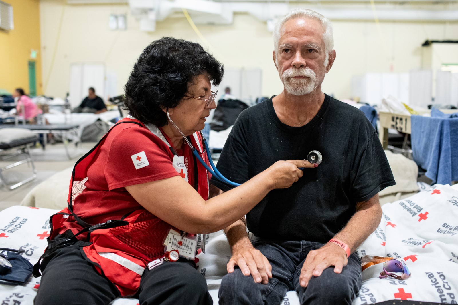 A Red Cross Disaster Health Services volunteer nurse assists a local resident who lost everything when storm surge inundated his home during Hurricane Helene. 