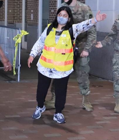 A Sewa volunteer manages traffic control at the state-run, federally-supported Center City Community Vaccination Center in the Pennsylvania Convention Center in Philadelphia. (