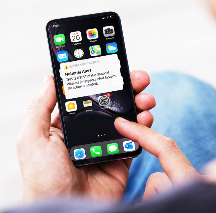 View of a IPhone with alert on screen saying: National Alert. THIS IS A TEST of the National Wireless Emergency Alert System. No action is needed.