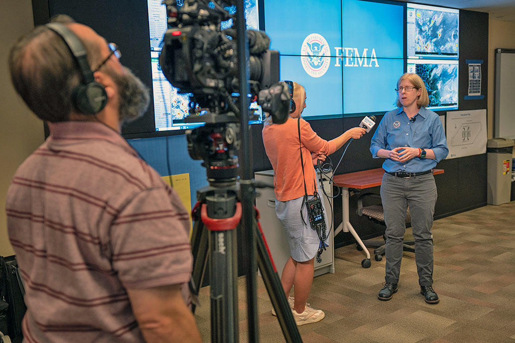 A woman being filmed talking into a microphone. 