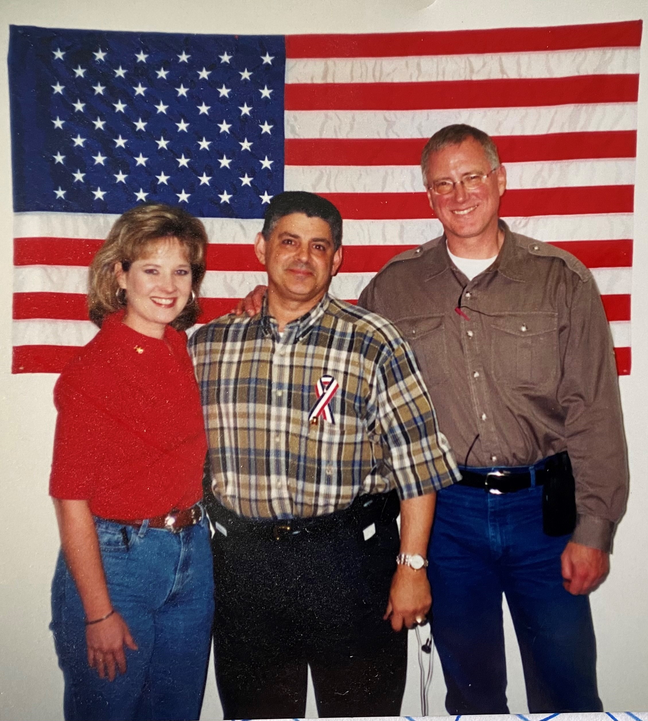 Sept. 14, 2001. Robert A. (Bob) Weaver (middle), U.S. Secret Service Agent from New York asked Lisa Nine (left) to hang up the American Flag when they first opened the re-located office from World Trade Center 7 to the John Jay College of Criminal Justice in New York City. 